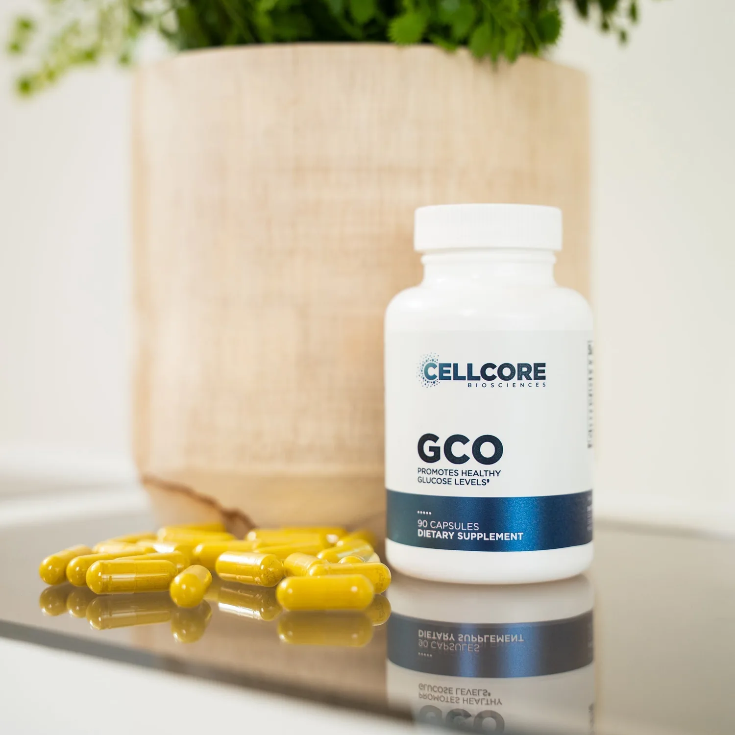 GCO bottle on a benchtop with its yellow capsules spread out in front