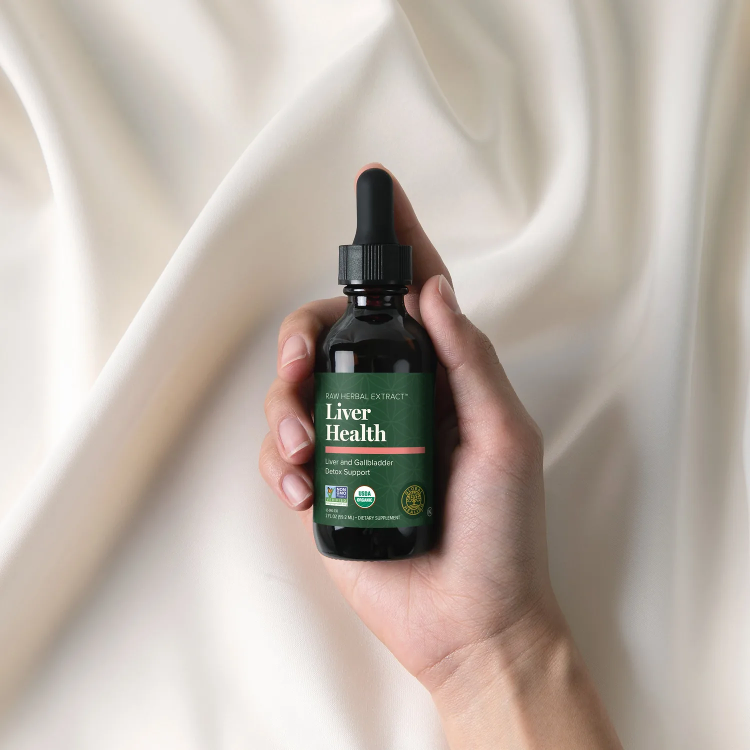 Hand holding a bottle of Global Healing Liver Health herbal extract