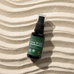 Global Healing Lung Health spray bottle lying on rippled sand