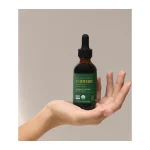 Global Healing Turmeric dropper bottle resting on an open hand