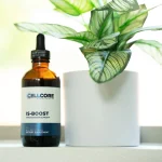 Amber dropper bottle of CellCore IS-BOOST on a windowsill beside a potted plant