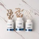The three open Liver Support Kit bottles with their capsules spilling out on a marble benchtop