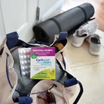 Boiron Cyclease Cramps box and blister sleeve tucked into a gym bag beside a yoga mat and trainers